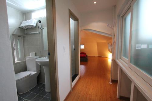 een badkamer met een toilet, een wastafel en een spiegel bij B My Guesthouse in Seoul