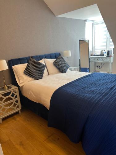 - une chambre avec un lit doté de draps et d'oreillers bleus dans l'établissement Druid House B&B, à Inverness