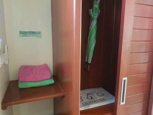 a closet with a green tie and a green towel at Wind Beach Resort in Koh Tao