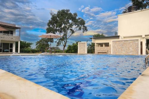 uma piscina com água azul e um guarda-sol em Finca Hotel Mana em Guamal