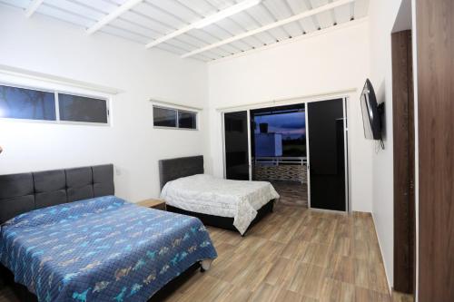 um quarto com uma cama e uma cama e uma janela em Finca Hotel Mana em Guamal
