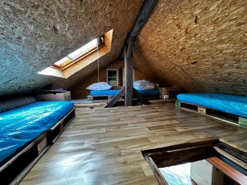 Habitación con 2 camas y suelo de madera. en Chata, en Nové Město pod Smrkem