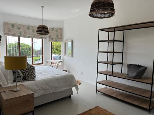 a bedroom with a bed and a book shelf at Living Waters in St Francis Bay