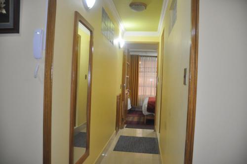un couloir menant à une chambre aux murs jaunes dans l'établissement COMODORO DEPARTAMENTOS, à Oruro