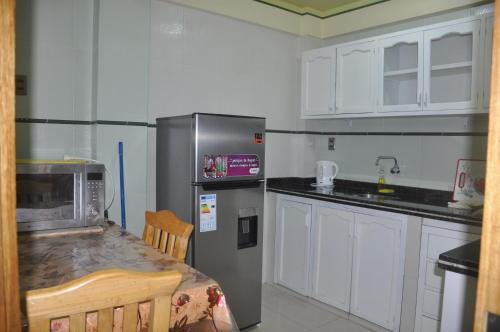 eine Küche mit einem Kühlschrank und einer Arbeitsplatte in der Unterkunft COMODORO DEPARTAMENTOS in Oruro