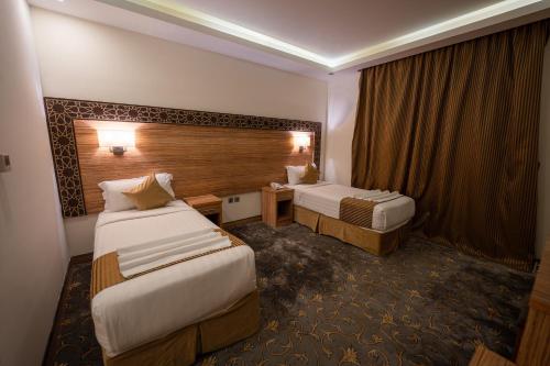 a hotel room with two beds and a desk at فندق سنود المروة in Mecca
