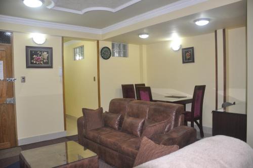 sala de estar con sofá y mesa en COMODORO DEPARTAMENTOS, en Oruro