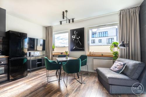 Green Harmony Apartment في سوسنوفييتس: غرفة معيشة مع أريكة وطاولة وكراسي