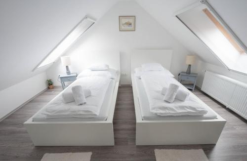 two beds in a room with a attic at Perle Vendégház in Kesztölc