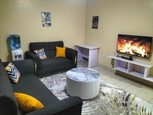 a living room with a couch and a flat screen tv at Weli Glamorous homestay in Naivasha