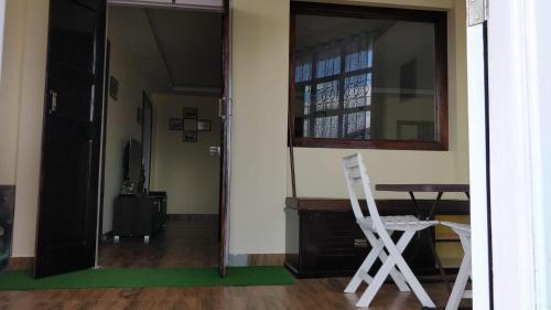 a room with a table and a chair and a mirror at Roseville (Entire Apartment) in Shillong