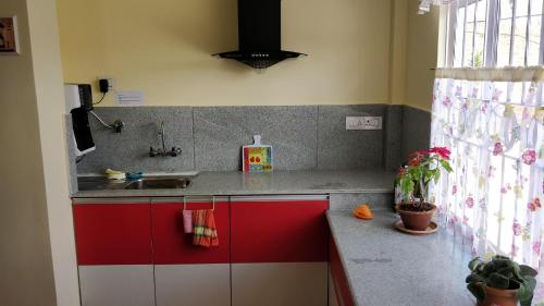 a kitchen with red and white cabinets and a sink at Roseville (Entire Apartment) in Shillong