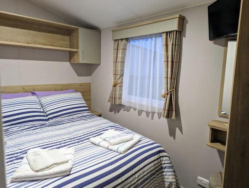a bedroom with a bed with towels on it at 3 Bedroom Heaven Home ll Summerhouse in Hastings