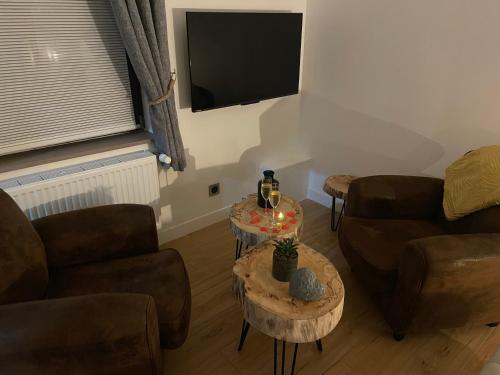 - un salon avec deux chaises et deux tables dans l'établissement Le domaine de la verrerie, à Landrecies