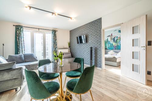 Green Harmony Apartment في سوسنوفييتس: غرفة معيشة مع طاولة وكراسي خضراء