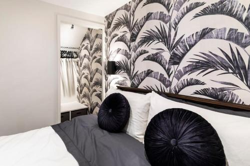 a bedroom with a bed with black pillows on it at The Holt - Ilkley, central location, stylish apartment in Middleton