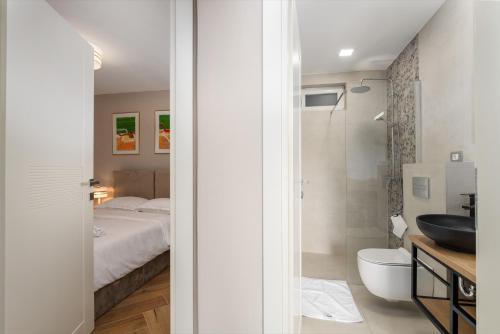a bathroom with a bed and a shower and a sink at Larum Apartmens in Vrsar
