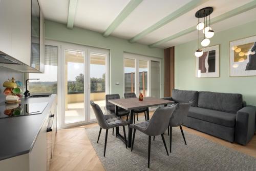 a kitchen and a living room with a table and chairs at Larum Apartmens in Vrsar
