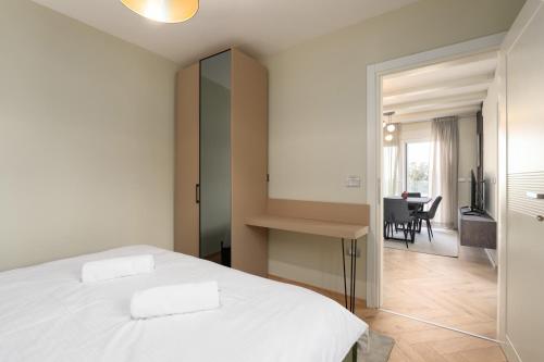a bedroom with a white bed and a dining room at Larum Apartmens in Vrsar