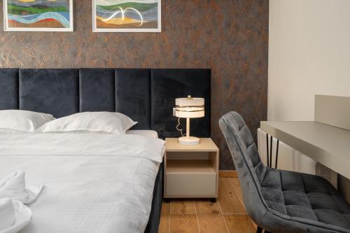 a bedroom with a bed and a chair and a table at Larum Apartmens in Vrsar