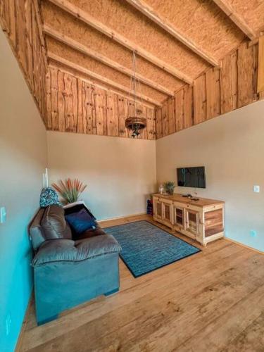 un soggiorno con divano e soffitto in legno di Rancho Safari - Corocoxó a Jaraguá do Sul