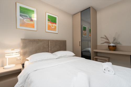 a bedroom with a large white bed with two pillows at Larum Apartmens in Vrsar