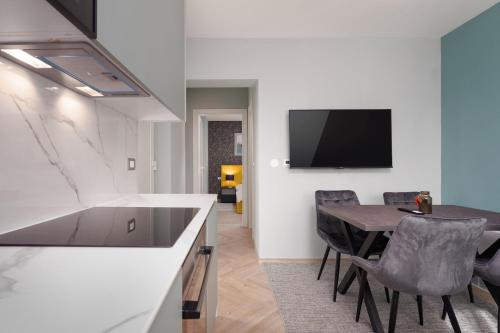 a kitchen and dining room with a table and a tv at Larum Apartmens in Vrsar