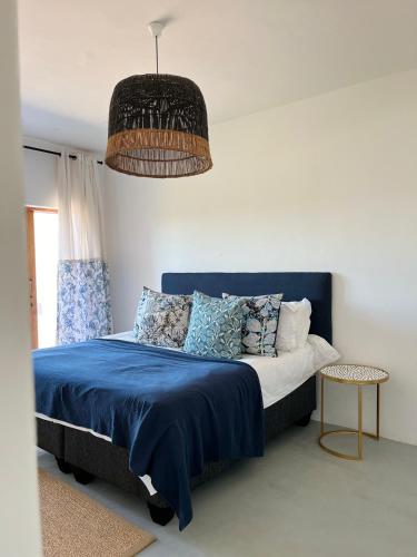 a bedroom with a blue bed with a blue blanket at Living Waters in St Francis Bay