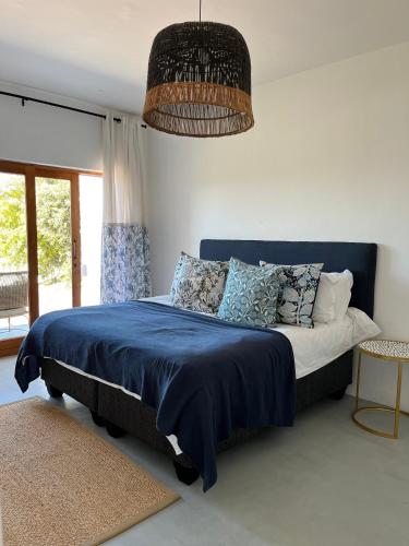 a bedroom with a bed with a blue comforter at Living Waters in St Francis Bay