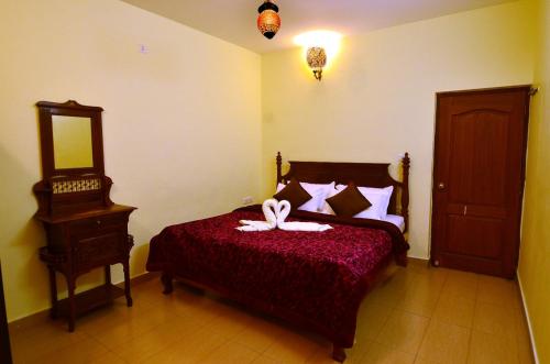 a bedroom with a bed with a bow on it at Al Safa Home Stay Un -Married And Stag Groups Not Allowed in Ooty