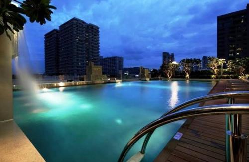 a large swimming pool in a city at night at Ivy Thonglor in Khlong Toei