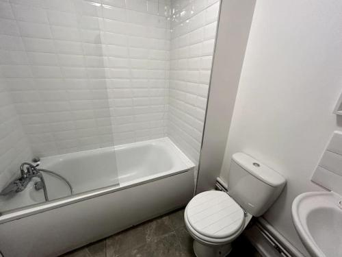 a bathroom with a tub and a toilet and a sink at Essex 2 Bedroom Flat near Station with Free Parking in North Ockendon