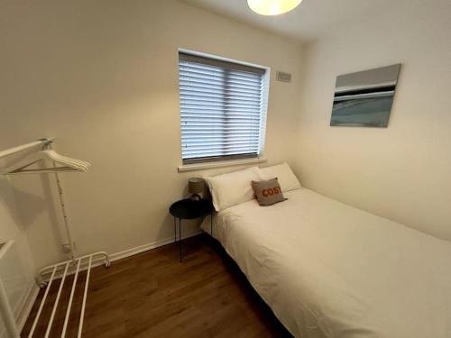 um quarto com uma cama com uma almofada em Essex 2 Bedroom Flat near Station with Free Parking em North Ockendon