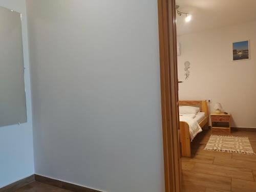 a door leading to a bedroom with a bed at Potyka Apartman in Tiszafüred