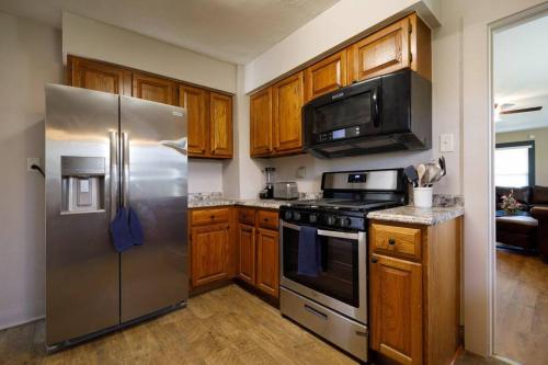 una cucina con elettrodomestici in acciaio inossidabile e armadietti in legno di Comfortable and close in to MU and Downtown a Columbia