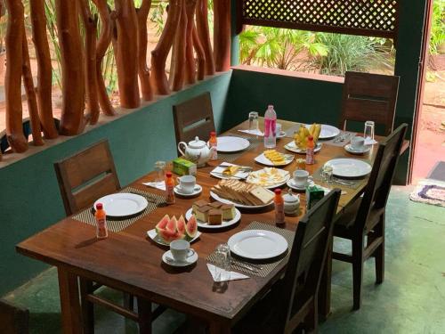 a wooden table with plates of food on it at Walawa Blue Sapphire in Udawalawe