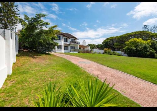 a large white house with a brick driveway at Living Waters in St Francis Bay