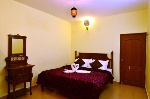 a bedroom with a bed with a bow on it at Al Safa Home Stay Un -Married And Stag Groups Not Allowed in Ooty