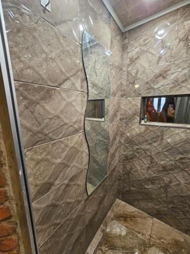 a shower with a glass door in a bathroom at Svečiu Namai in Pagiriai