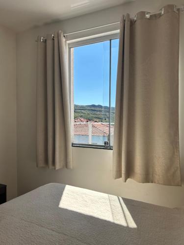 a bedroom with a window with a view at Apartamento inteiro com garagem em Diamantina/MG in Diamantina