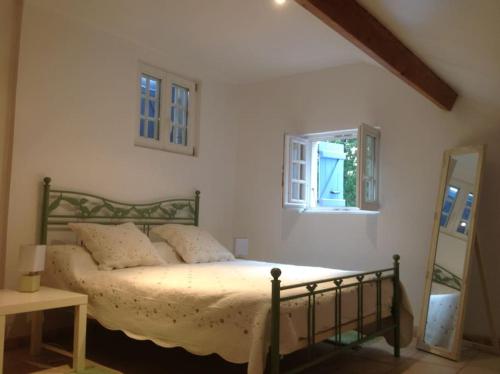 Schlafzimmer mit einem Bett und einem Fenster in der Unterkunft Villa romantique avec Poolhaus in Cotignac