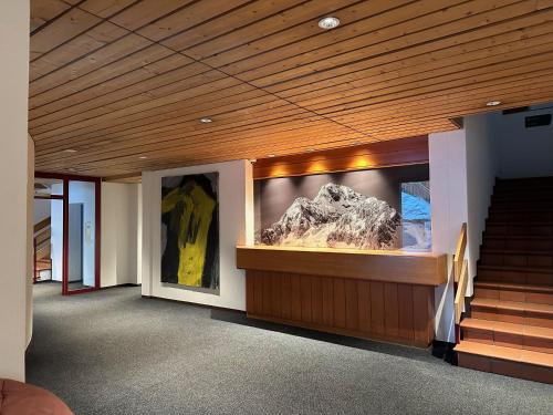 a room with stairs and a large painting on the wall at Schöne Ferienwohnung im Zentrum von St. Moritz in St. Moritz