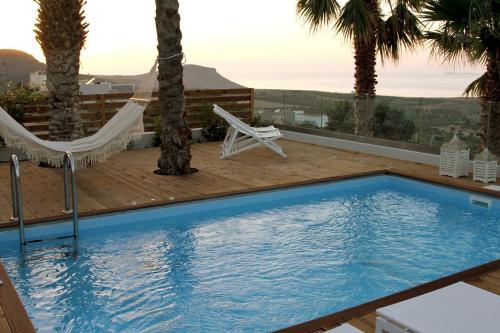 a swimming pool with a hammock and a deck at Cretan Luxury Villa by Smaris Collection in Kokkíni Khánion