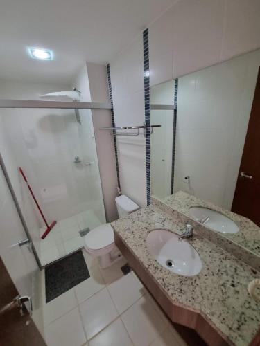 a bathroom with a sink and a shower and a toilet at Flat Veredas Rio Quente-GO in Rio Quente