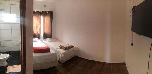 um pequeno quarto com uma cama e uma casa de banho em Pousada Cactos em Chapada dos Guimarães
