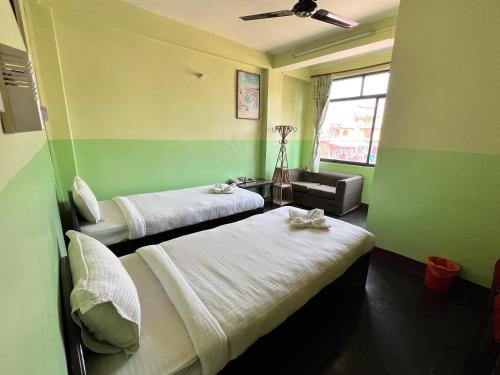 two beds in a room with green walls at Metro Eco Hotel in Kathmandu