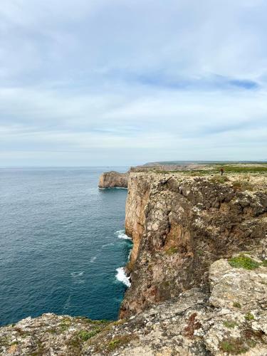 a person standing on a cliff near the ocean at Casa Sarguito in Sagres