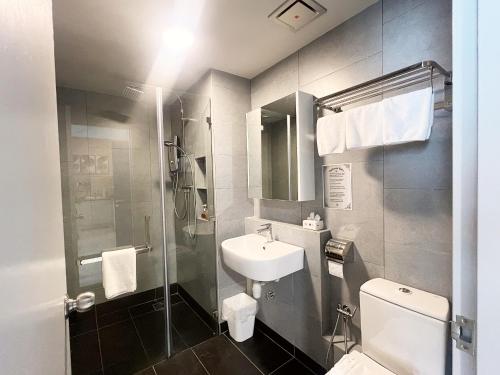 a bathroom with a sink and a toilet and a shower at Jesselton Quay Kota Kinabalu City Centre by LW Suites in Kota Kinabalu