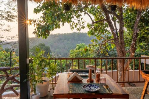 a table on a balcony with a view of the mountains at Simroseate in Agonda