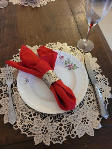 a white plate with a red napkin on a table at Na trilha da ostra in Brumadinho